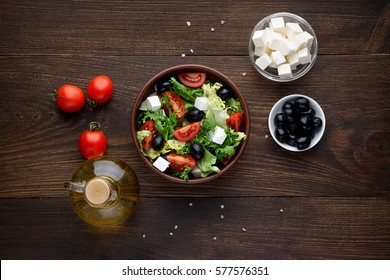 Mediterranean Salad With Olives And Feta In Bowl On Rustic Wooden Table. Top View.