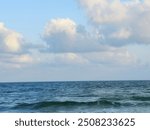 The Mediterranean Sea with blue cloudy sky at sunrise time in Alexandria Egypt, connected to the Atlantic Ocean, surrounded by the Mediterranean Basin, and almost completely enclosed by land