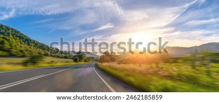 Mediterranean sea coast road into mountains horizon in summer with beautiful bright sun rays - wide angle panorama shot with high speed motion blur effect