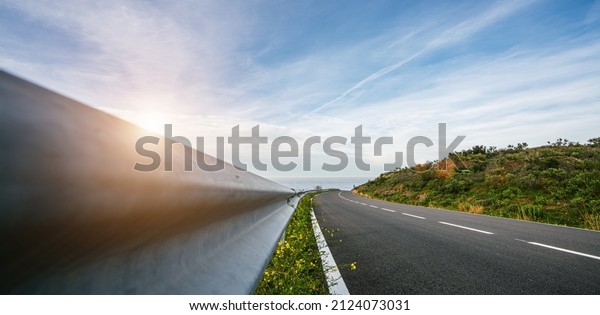 Mediterranean\
sea coast road into mountains horizon in summer with beautiful\
bright sun rays - wide angle panorama\
shot