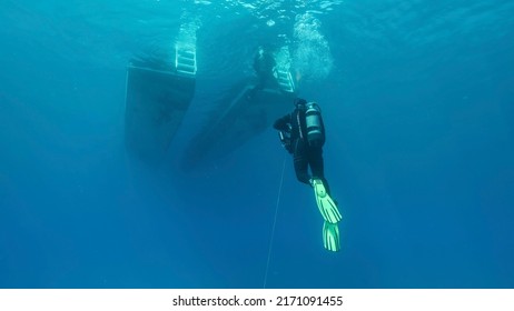 MEDITERRANEAN SEA, CYPRUS - AUGUST, 2021: Scuba Diver Swim Towards Diving Boat In Blue Water. Mediterranean Sea, Cyprus