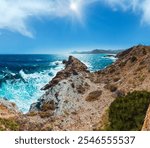 Mediterranean sea summer rocky coast view with unrecognizable man on cape and lighthouse El hoyo del faro (Portman, Costa Blanca, Spain).