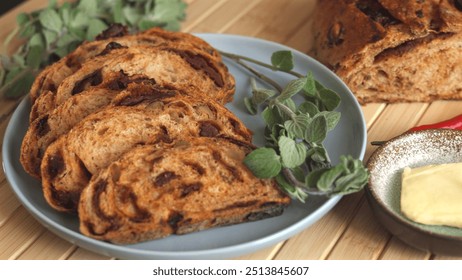 Mediterranean-style vegan plate featuring sliced bread with tomato and olives baked into loaf served alongside vegan butter hint of chili fresh greens Eco-conscious dish that is nutritious satisfying