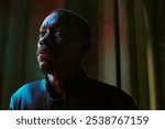 Medium close up of African American priest immersed into own thought while standing in church