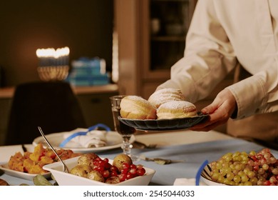 Medium close up of unrecognizable woman serving fresh baked donuts covered with powdered sugar - Powered by Shutterstock