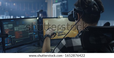 Medium close-up of a developer playing a VR game or simulator controlling a virtual Mars rover