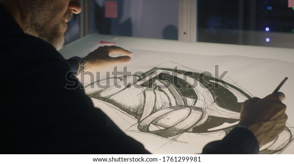 Medium close-up of a male car designer drawing\
concept art