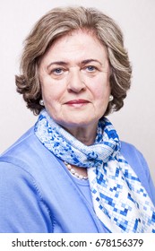 Medium Close-up Portrait Of An Elegant Amd Well Maintained Senior Woman (in Her Late 60's) Smiling A Toothy Smile To The Camera.