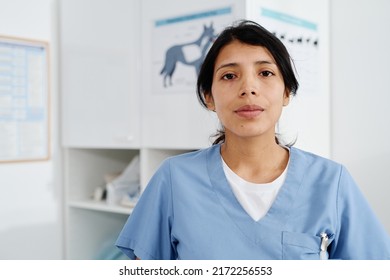 Medium Close-up Portrait Of Young Adult Hispanic Woman Working In Vet Clinic Standing In Exam Room Looking At Camera