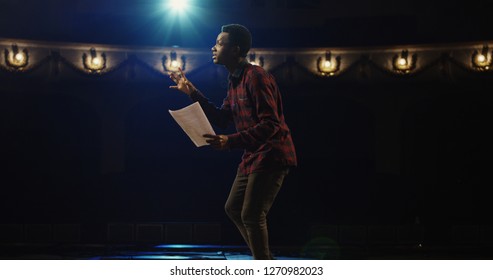 Medium close-up shot of an actor performing a monologue in a theater while holding his script