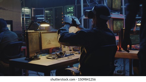 Medium close-up of a soldier using VR headset and gloves while sitting at his desk - Powered by Shutterstock