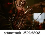 Medium closeup of unrecognizable Black jazz musician playing saxophone on stage in local bar