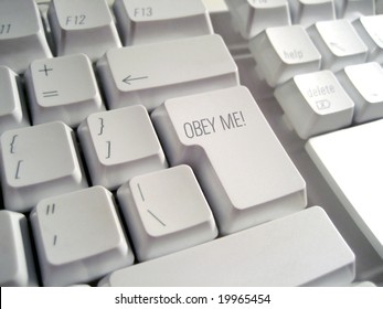 Medium close-up of a white computer keyboard with the words "Obey Me' superimposed onto the return key