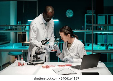 Medium full shot of biracial researchers working together in laboratory - Powered by Shutterstock