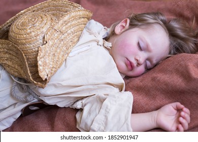 Medium horizontal portrait of adorable blond toddler boy dressed in 17th Century costume sleeping soundly