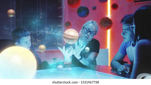 Medium long shot of teacher explaining to students with holographic rendition of the solar system