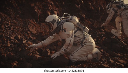 Medium Long Shot Of Two Astronauts Collecting Rock Samples On Mars