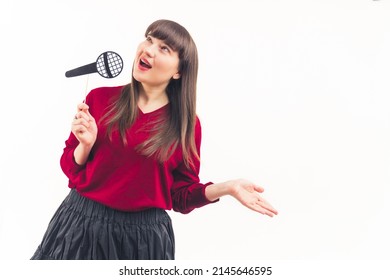 Medium Long Studio Shot Of Positive Caucasian Woman In Her 20s Holding Fake Paper Microphone And Singing, Pretending To Be A Pop Star. High Quality Photo