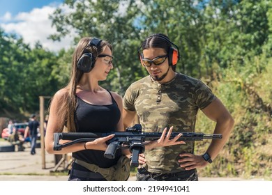 Medium Outdoor Shot Of A Caucasian Heterosexual Couple Spending Their Free Time At A Shooting Range To Pursue Their Hobby. Shooting With The Instructor Concept. High Quality Photo