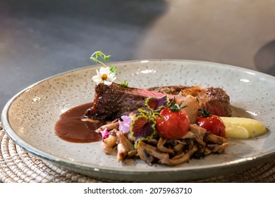 Medium Rare Beef Steak And Fried Sliced Mushroom Are Decorated By Little Flower On White Dish, Ready To Serve And Eat.