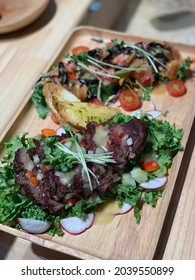 Medium Rare Ribeye Steak With Herbs And Garlic Bread On The Wooden Tray