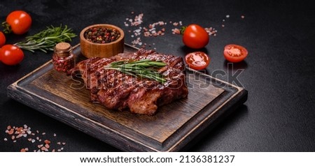 Medium rare sliced grilled striploin beef steak served on wooden board