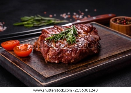 Medium rare sliced grilled striploin beef steak served on wooden board