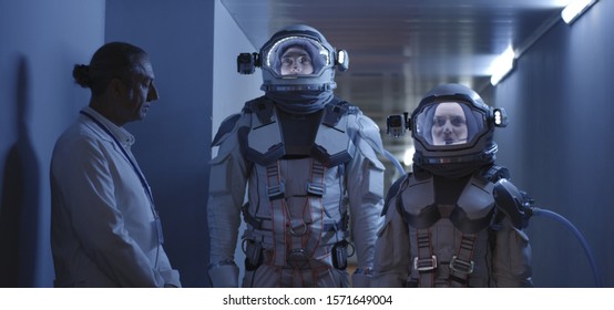 Medium shot of astronauts standing in a corridor while waiting for their departure - Powered by Shutterstock