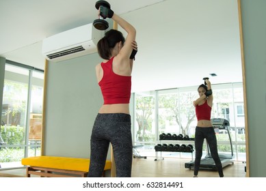 Medium Shot From Back Lady Hand Lift Up Dumbbell One Hand At Gym For Bodybuilder ( In Overhead Triceps Exercise Concentration Curls Action) With Black Weight Lifting Gloves And Red Vest