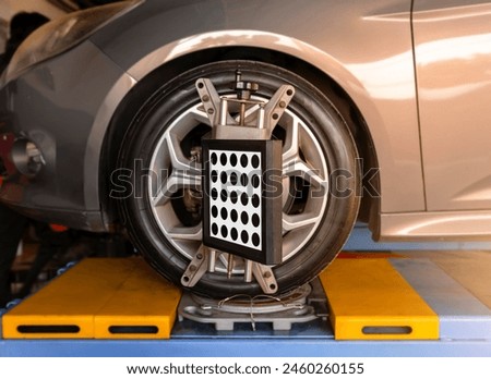 Medium shot of Car wheel alignment is in progress. auto camber toe check fixing. sensor during suspension adjustment and automobile wheel alignment work at the repair service station.