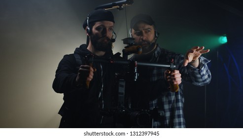 Medium shot of a director instructing a steadicam using cameraman on a film set
