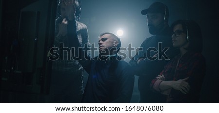 Medium shot of a director sitting down into his chair and starting giving instructions