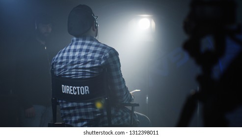 Medium shot of a director sitting in his chair on a film set