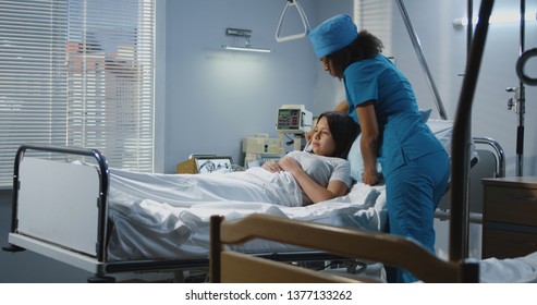 Medium Shot Of Doctor And Male Nurse Lifting Patient To Bed In Hospital