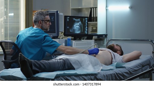 Medium shot of a doctor performing an ultrasound examination on a man - Powered by Shutterstock