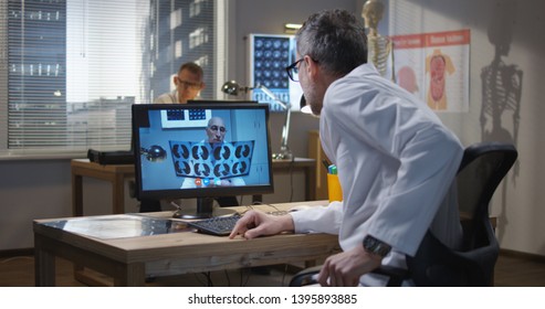 Medium Shot Of Doctors Discussing MRI Scan Results During A Video Call