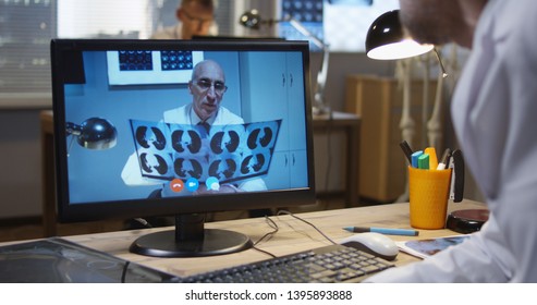 Medium Shot Of Doctors Discussing MRI Scan Results During A Video Call