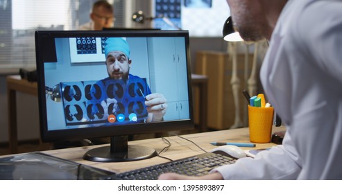 Medium Shot Of Doctors Discussing MRI Scan Results During A Video Call