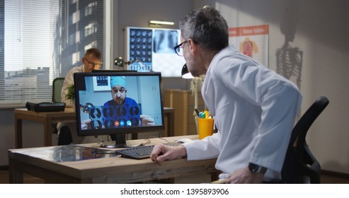 Medium Shot Of Doctors Discussing MRI Scan Results During A Video Call