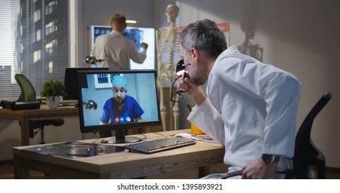 Medium Shot Of Doctors Discussing MRI Scan Results During A Video Call