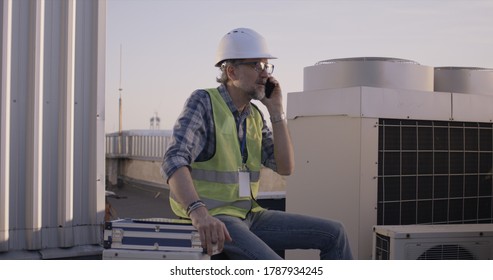Medium shot of an engineer having phone call on a cell tower