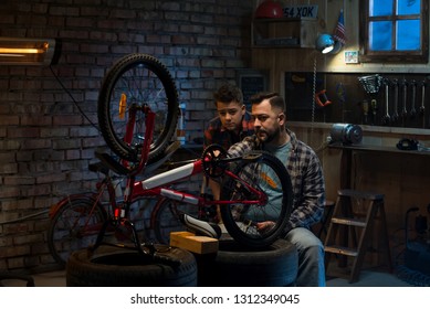 Medium Shot Of Father And Son Talking About Bike Repair In A Garage