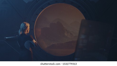 Medium shot of a female astronaut looking out of the window of a Martian base