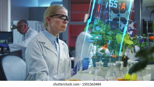 Medium shot of a female scientist using a holographic display screen