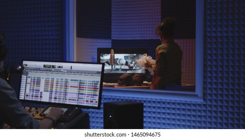 Medium Shot Of Foley Artist And Sound Engineer Working In Studio