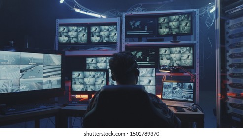 Medium Shot Of A Hacker Watching Hacked Security Camera Footage