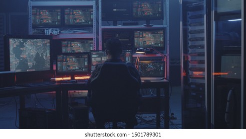 Medium shot of a hacker working with multiple monitors