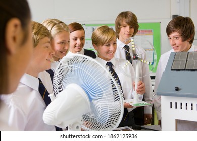 A Medium Shot Of Happy Students Experimenting With A Model Wind Turbine In A Science Class.