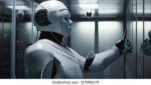 Medium shot of a humanoid robot checking servers in a data center while holding a tablet