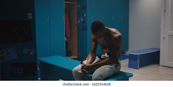 Medium shot of lonely man undressing in locker room - Powered by Shutterstock